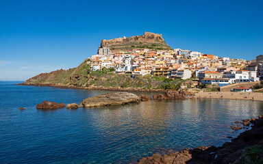 View of Castelsardo with beach and the fortress high up on the cliffs, Sassari, Sardinia, Italy