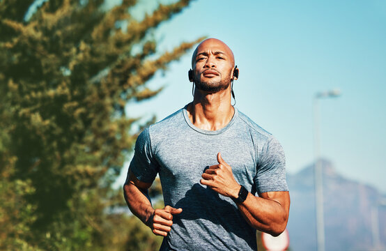 Fitness, man and outdoor with music for running, workout and cardio exercise in Brazil. Sports person, active and earphones in city for marathon preparation, determination and training goal ambition