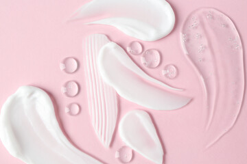 Smears of different cosmetic products on pink background, flat lay