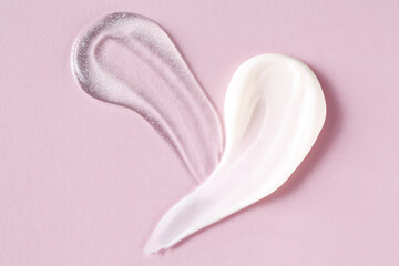 Smears of cosmetic products on pink background, top view