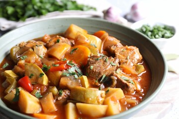Delicious stew with vegetables in bowl on table, closeup