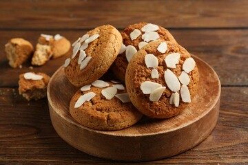 Tasty cookies with almond flakes on wooden table, closeup