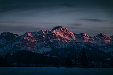 A mountain peak bathed in the warm alpenglow of sunset