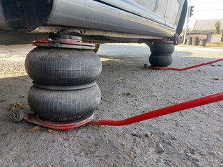 car in tire service on pneumatic jacks. Replacing car wheels