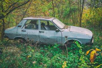 Image of an old Dacia 1310 car wreck in the outdoors.An old abandoned Dacia romanian car wreck at the side of the road