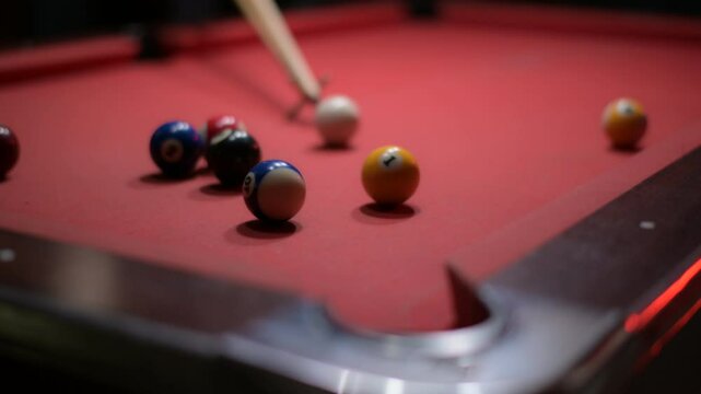 Dynamic Recreation Red Pool Table with Billiard Balls and Cue Stick in Action for Exciting Sport Game Experience