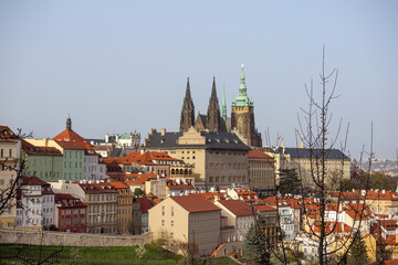 view of the old town church and buildings with red tiled roofs against a blue sky background