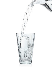 Pouring soda water from jug into glass on white background