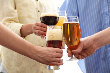 People with different types of beer clinking glasses, closeup