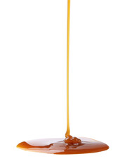 Tasty caramel sauce dripping on white background, closeup