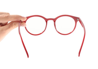 Woman holding glasses with red frame on white background, closeup