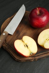 Fresh ripe red apples and knife on grey textured table