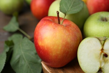 Different ripe apples on wooden table, closeup