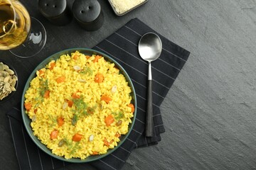 Delicious pumpkin risotto served on black table, flat lay. Space for text
