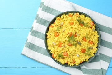 Delicious pumpkin risotto on light blue wooden table, top view. Space for text