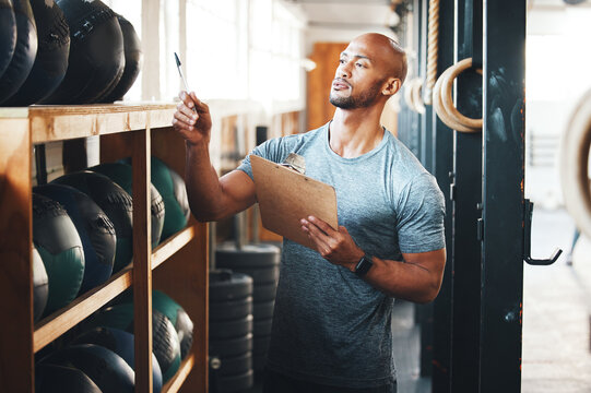 Planning, clipboard and checklist with man in gym for fitness instructor, inventory and membership record. Workout schedule, personal trainer and equipment supervisor with person in health facility