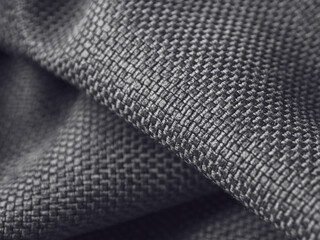 Macro photography of dark fabric, highlighting its texture and depth of color, creating an atmosphere of elegance and comfort