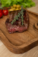 Hot steak with rosemary on a wooden board.