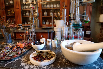 Chemistry flasks with liquids, herbs of medicinal plants in an old pharmacy
