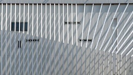 Architecture details of white facade with metal bending bars with light and shadow