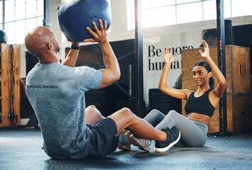 Fitness, personal trainer and exercise with medicine ball, sit ups and throw to partner to workout abdominal muscle. Man, woman and training equipment for core strength, help and body health in gym