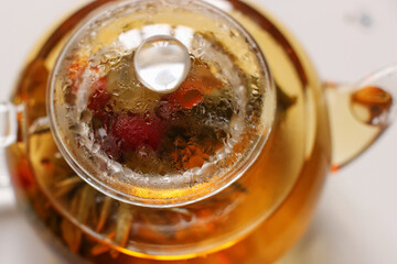 Tea leaves and citrus fruits in a glass teapot
