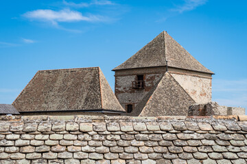 Ancient medieval stone castle with tower and roof against clear sky