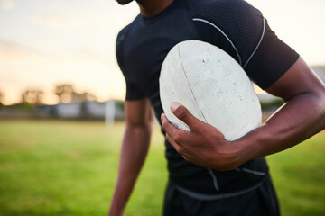 Obraz premium Rugby, man and hand in stadium with ball, training ambition and ready for tournament. Closeup, sport and athlete on field grass for fitness, game competition and skill development in New Zealand