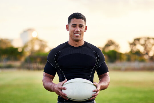 Rugby, portrait and happy man with ball for game, sports and competition at pitch at sunset. Player, smile and confident athlete at field for body health, exercise and fitness outdoor in Argentina