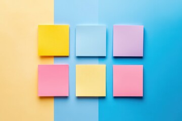 Fototapeta premium Flat lay of colorful sticky notes arranged in a grid pattern on a split yellow and blue background, perfect for creative organization and planning themes