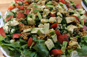 green salad with avocado, tomatos and feta cheese with french mustard