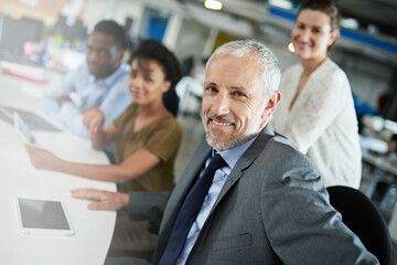 Portrait, man and business people in meeting, opportunity and magazine agency with news room. Office, group and employees with tech, journalist or editing with mature person and research for project