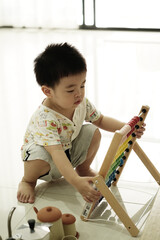 Asian boy playing colorful abacus at home