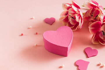 Fototapeta premium Pink tulips and hearts on a light pink background