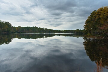 A glassy smooth reservoir pond allows the beautiful fall trees along the shore to cast an amazing...