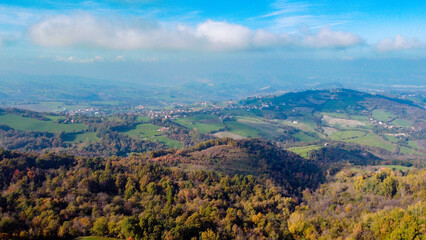 Vista aerea dei coloratissimi boschi e prati dell'Appennino modenese durante una soleggiata giornata d'autunno