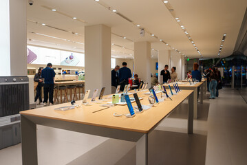 A spacious electronics store in Shanghai features sleek design, wooden tables with smartphones, bright lighting, and staff assisting customers.