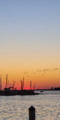 Fototapeta premium October Orange Sunset over a barrier island by the Intracoastal Waterway in Perdido Key, Florida