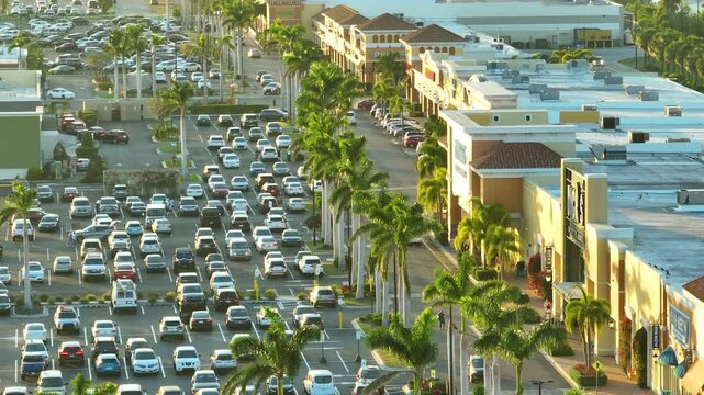 Many cars parked on a parking lot in front of a shopping mall in Florida. Concept shopping and urban transportation.
