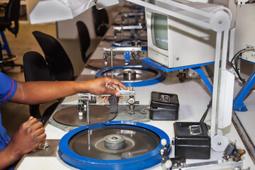 diamond polishing machine grinding cutting at the spinning wheel in a diamond polishing factory, african worker polishing a diamond