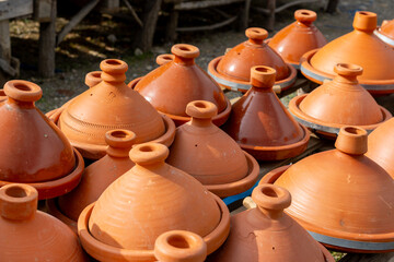 Tagine clay pots displayed on the shelf for sale. Morocco. The tagine is a cone-shaped cooking pot with a flat rim and a tall, conical lid.