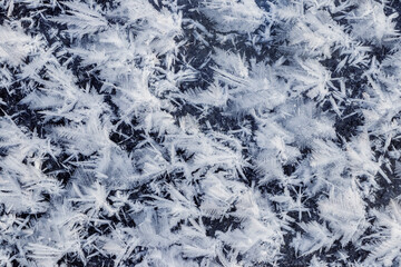 Big fluffy snowflakes on the surface of the ice. Winter and Christmas background