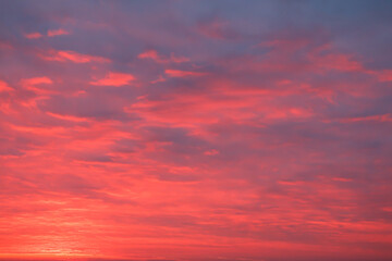 A dramatic sunrise sky filled with vibrant pink and purple clouds, creating a stunning and colorful cloudscape. 