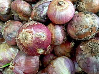 A pile of red onions seen up close