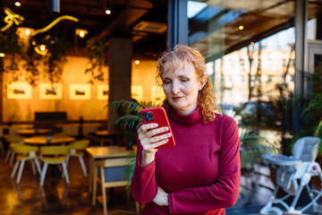 Woman using smartphone in a modern cafe with casual ambience