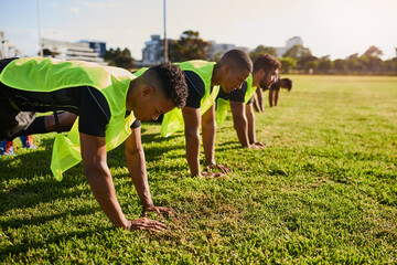 Men, rugby or grass field with push ups for fitness training, team practice or workout at outdoor stadium. Male people, group or football players with exercise, preparation or getting ready for sport