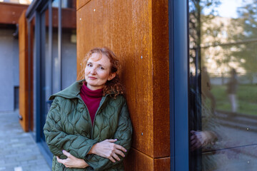 Confident mature woman standing by modern building outdoors