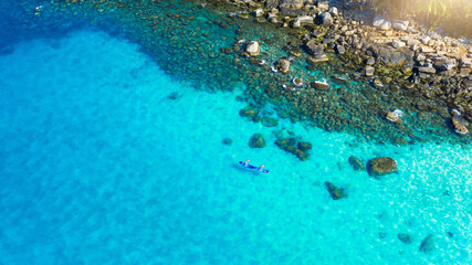Ocean, drone and people on paddle board for adventure holiday, water sports and outdoor fun. Nature, calm beach and aerial view of couple on surf for travel, summer vacation and tropical island coast