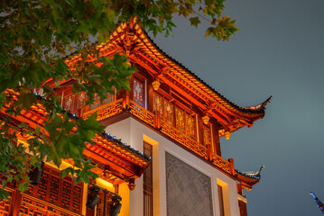 A traditional Chinese building in Shanghai features ornate wooden carvings and a curved roof,...