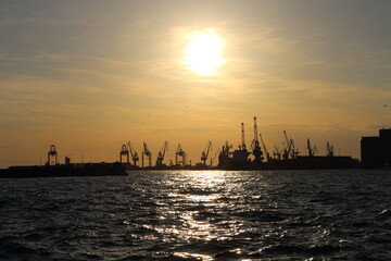 Industrial Port Cranes Silhouetted Against Sunset on the Waterfront